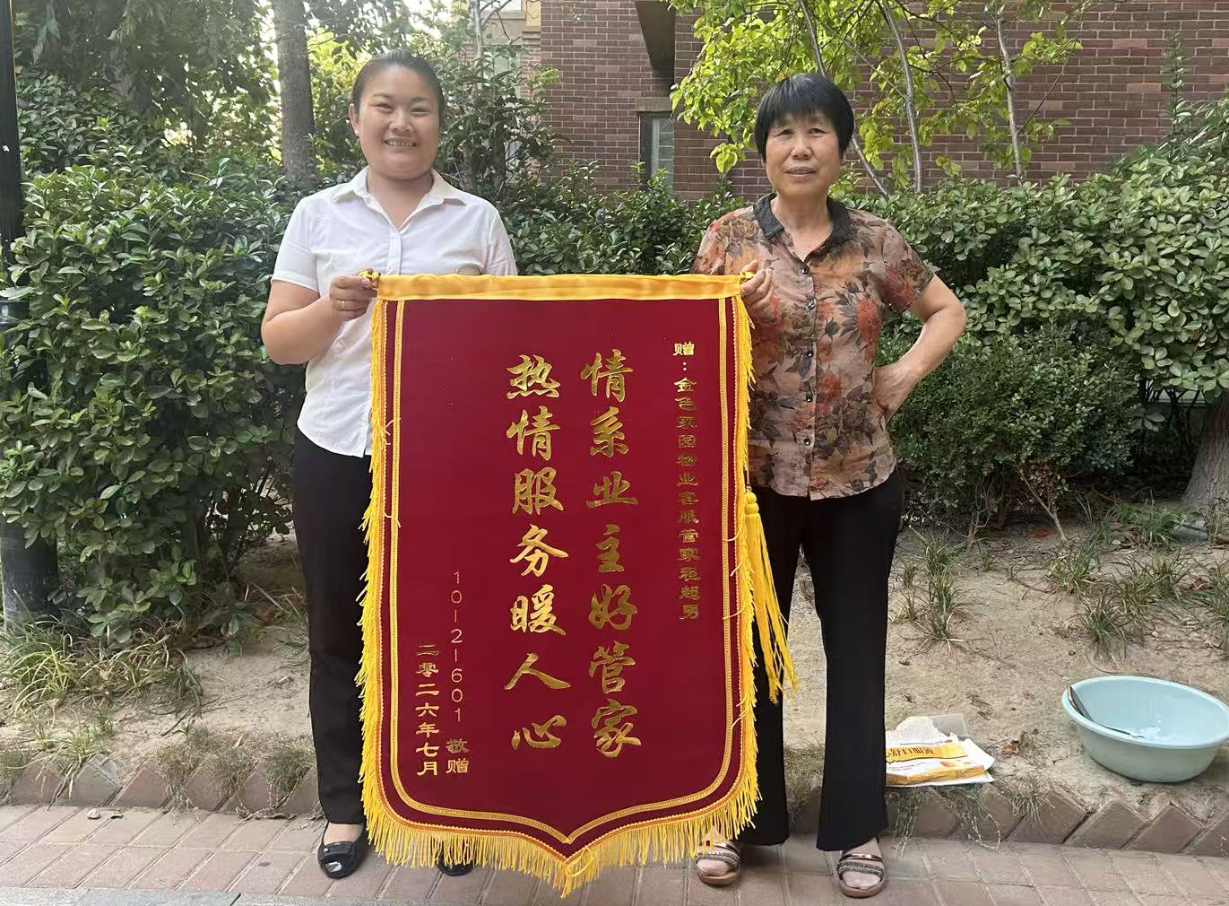 7月23日，小区业主将一面锦旗送至晟地物业客服管家程超男手中。.jpg