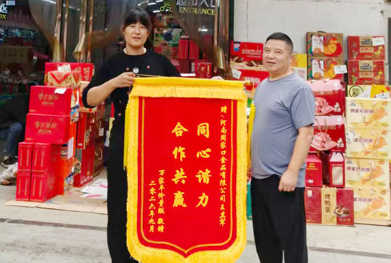 9月万家平价量贩向河南周家口食品川商太康部业务王其军赠予“同心协力，合作共赢”锦旗.jpg